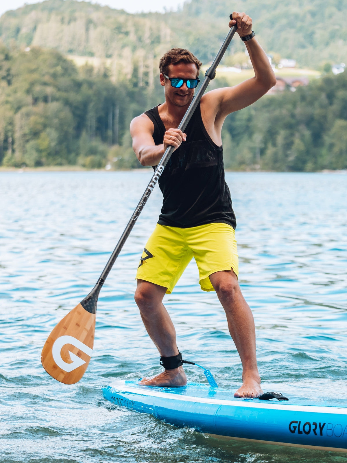 Ein Mann mit einer verspiegelten Sportbrille sthet auf einem Stand Up Paddel Board; Credits: Glory Boards