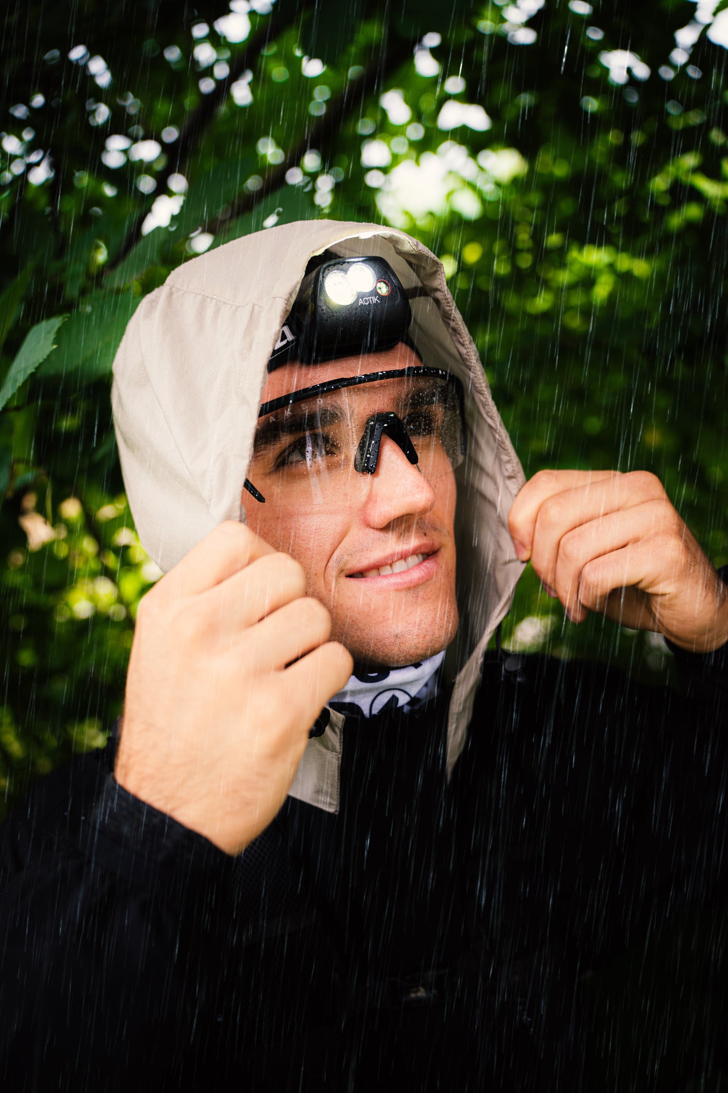 Ein junger Mann steht im Regen, seine Augen werden von einer klaren Sportbrille geschützt; Credits: Elias Neier