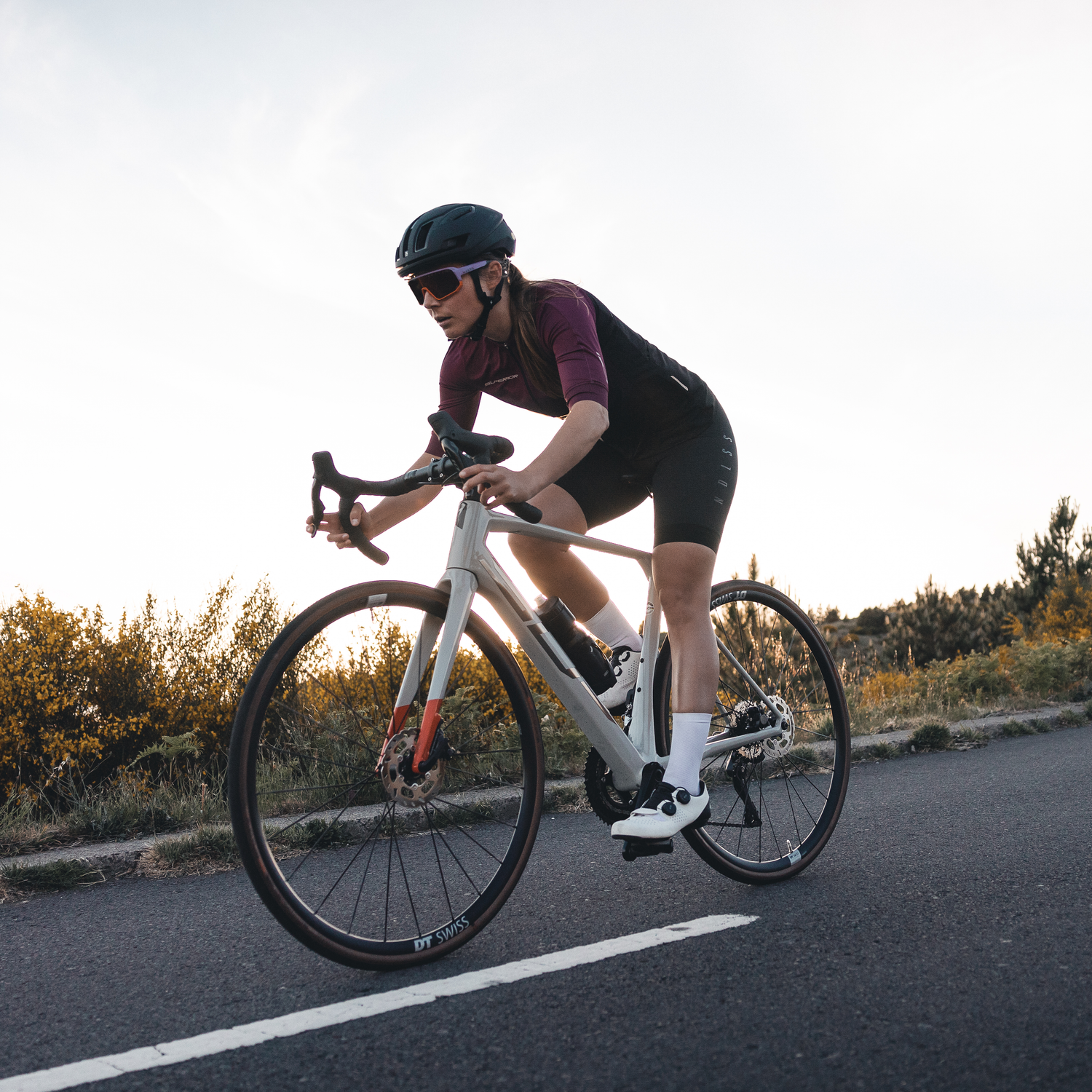 Ein Radfahrerin fährt mit ihrer Fahrradbrille mit schwarzen Gläsern auf einer Straße; Credits: Mathäus Gartner