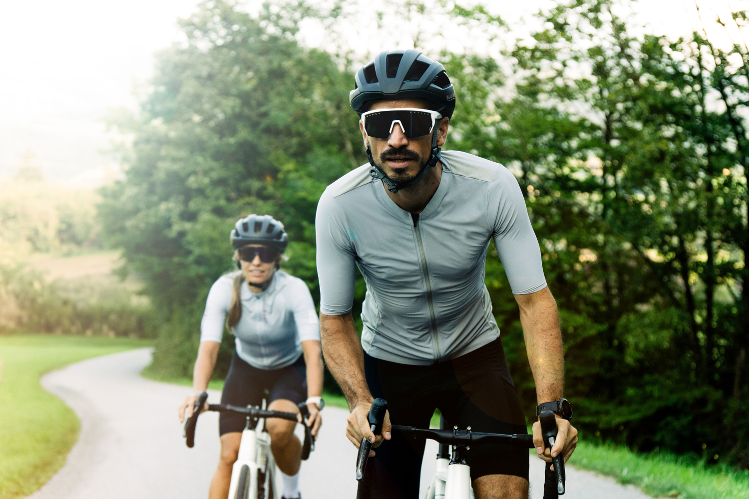Zwei Radfahrer tragen Fahrradbrillen mit schwarzen Gläsern und fahren auf die Kamera zu; Credits: Elias Neier