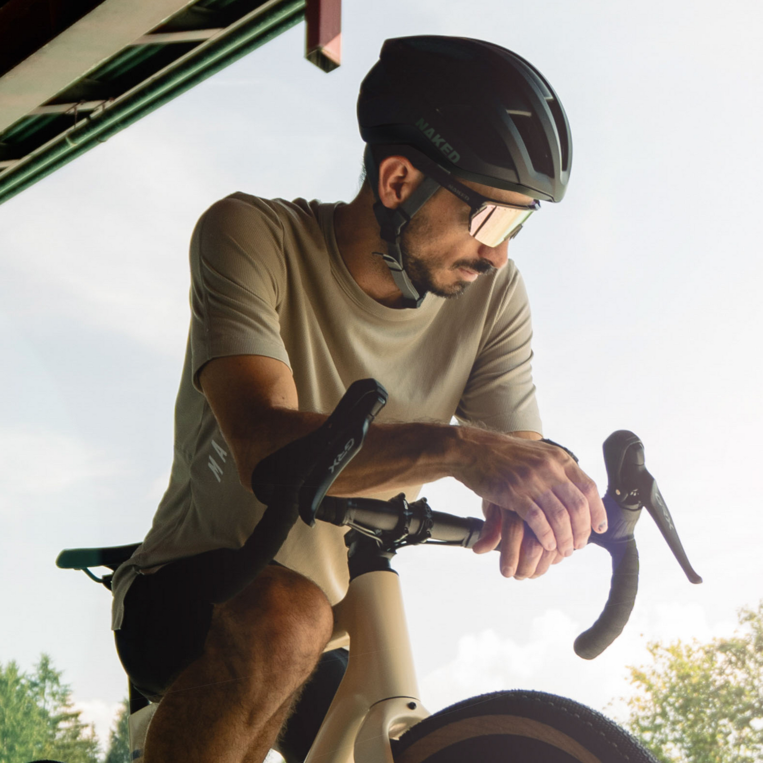 Ein Mann lehnt auf seinem Fahrradlenker; er trägt einen Rennradhelm und eine Fahrradbrille; Credits: Elias Neier